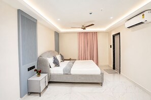 A modern bedroom with a bed, bedside table, and a ceiling fan. - The Canvas by Redolive 2bhkgachibowli Hitech (Hyderabad)