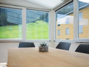 A conference room with a wooden table, chairs, and a glass container with plants and stones labeled 'INDOOR GREENS'. - Skistrasse 8B Appartement/Fewo, Dusche oder Bad, WC 3½-Zimmerwohnung by Interhome (Davos)
