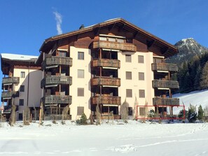 A multi-story hotel with balconies, a ski slope in the background, and a mountainous landscape. - Bünda Residenz 101 Appartement/Fewo, Dusche oder Bad, WC 4½-Zimmerwohnung by Interhome (Davos)