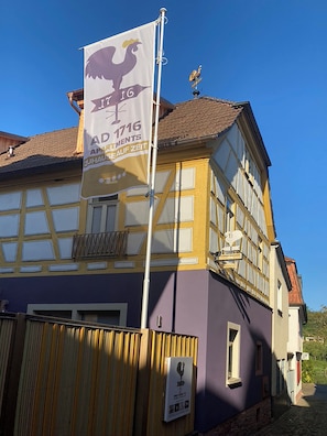 A building with a flag displaying the year 1716 and the text 'AD 1716 APARTMENTS ZUHAUS AUF ZEIT'. - Maisonette Apartment - The Dovecote - AD1716 (Marktheidenfeld)