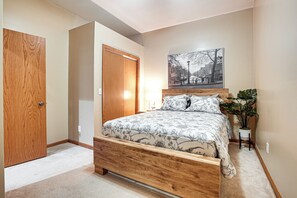 A bedroom with a wooden bed, a nightstand, a potted plant, and a wall-mounted picture. - Game Room, Screened Porch! Howard A-Frame Chalet (Howard)