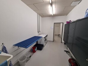 A laundry room with a washing machine, drying rack, and storage cabinets. - Mühlestrasse 3C Appartement/Fewo, Dusche und Bad, WC 3½-Zimmerwohnung by Interhome (Davos)