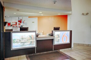 A reception desk with a sign that reads 'Well leave the light on for you.'