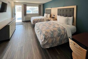 A hotel room with two beds, a TV, a desk, and a window with curtains. - 2 Full Beds | Non-Smoking (East Windsor)