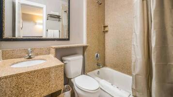 Un baño con lavamanos de encimera de granito, inodoro y bañera.