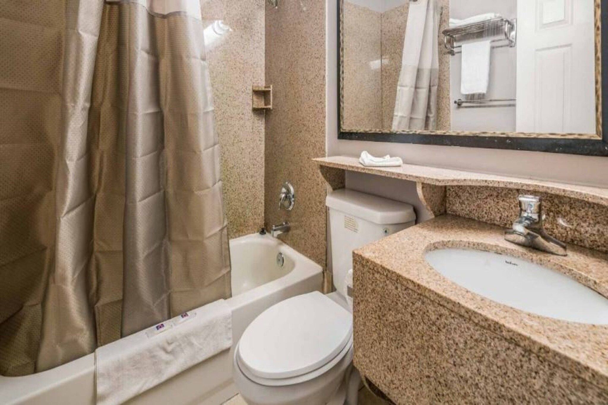A bathroom with a bathtub, toilet, and sink.