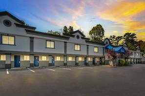 A row of motel rooms with a parking lot in front. - 1 Full Bed | Smoking (Toms River)