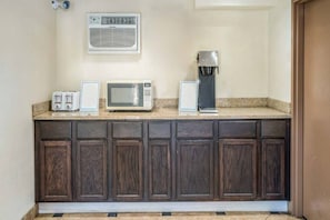 Eine Küche mit Mikrowelle, Toaster und Kaffeemaschine auf der Arbeitsplatte sowie Schränken darunter.
