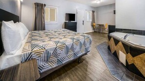 A hotel room with a bed, a bathroom with a bathtub, a desk, and a chair. - 1 Full Bed|Mobility|RI Shwr|Nsmk (Toms River)