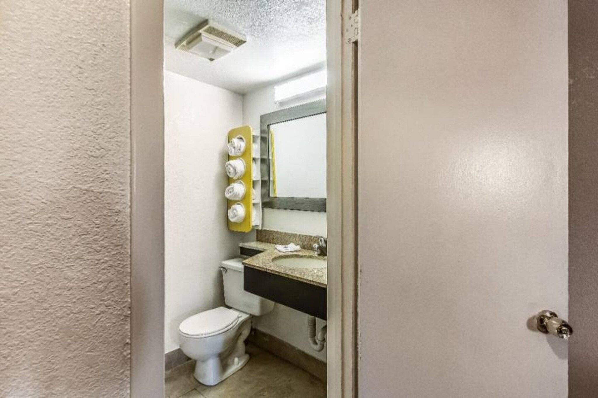 Une petite salle de bain avec des toilettes, un lavabo et un miroir.