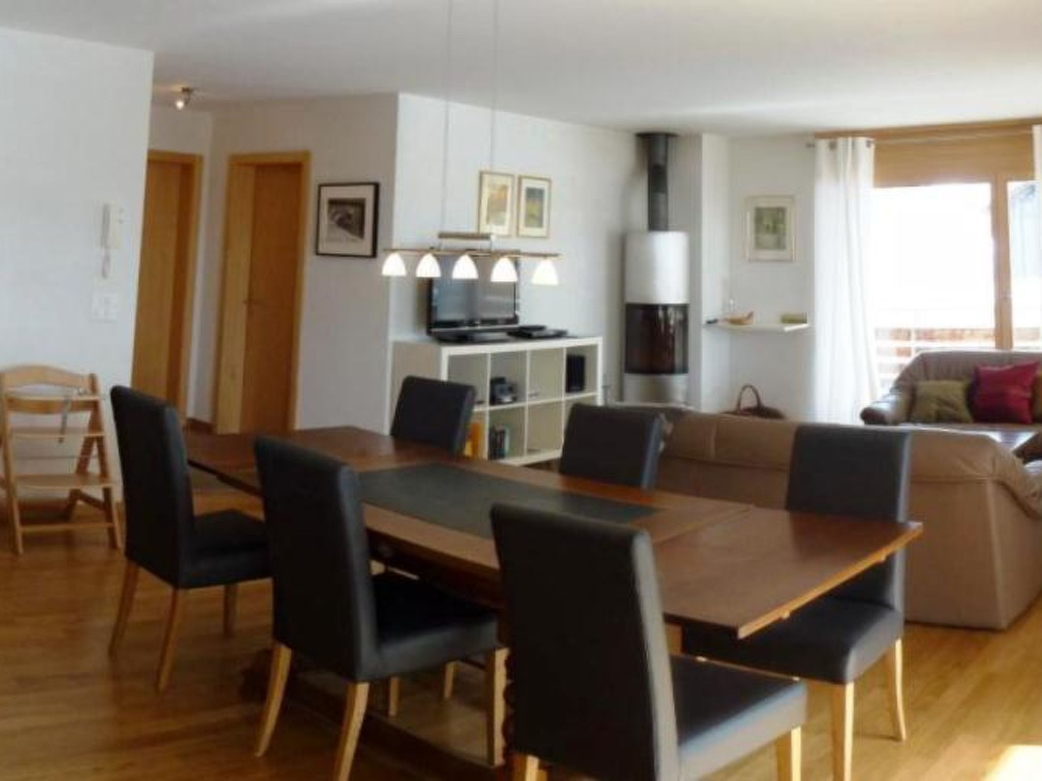 Ein modernes Wohnzimmer mit Essbereich, einer Couch und einem Kamin.
