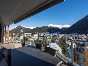 A balcony with a view of a snow-covered mountain range and a town below. - Scarlett Suot 63 Appartement/Fewo, Dusche oder Bad, WC 4-Zimmerwohnung by Interhome (Davos)