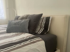 A bed with a striped bedspread, two pillows, and a headboard. - Rex 33 Appartement/Fewo, Dusche oder Bad, WC 2½-Zimmerwohnung by Interhome (Davos)