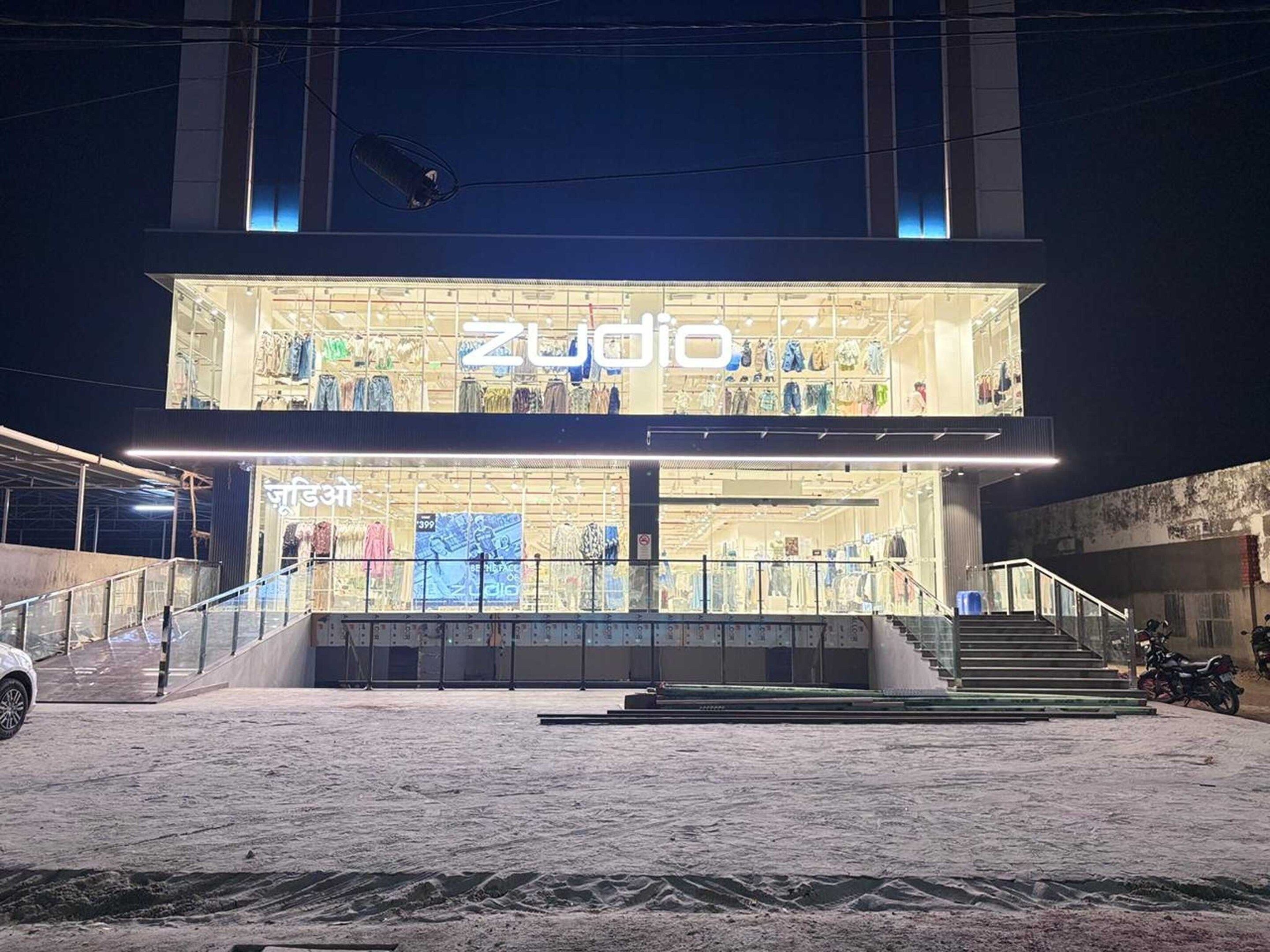 A two-story building with a brightly lit storefront displaying various items.