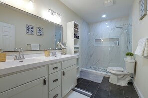 Un baño moderno con lavamanos doble, inodoro y zona de ducha.