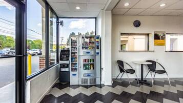 A modern interior with vending machines, a seating area, and a view of the outside.