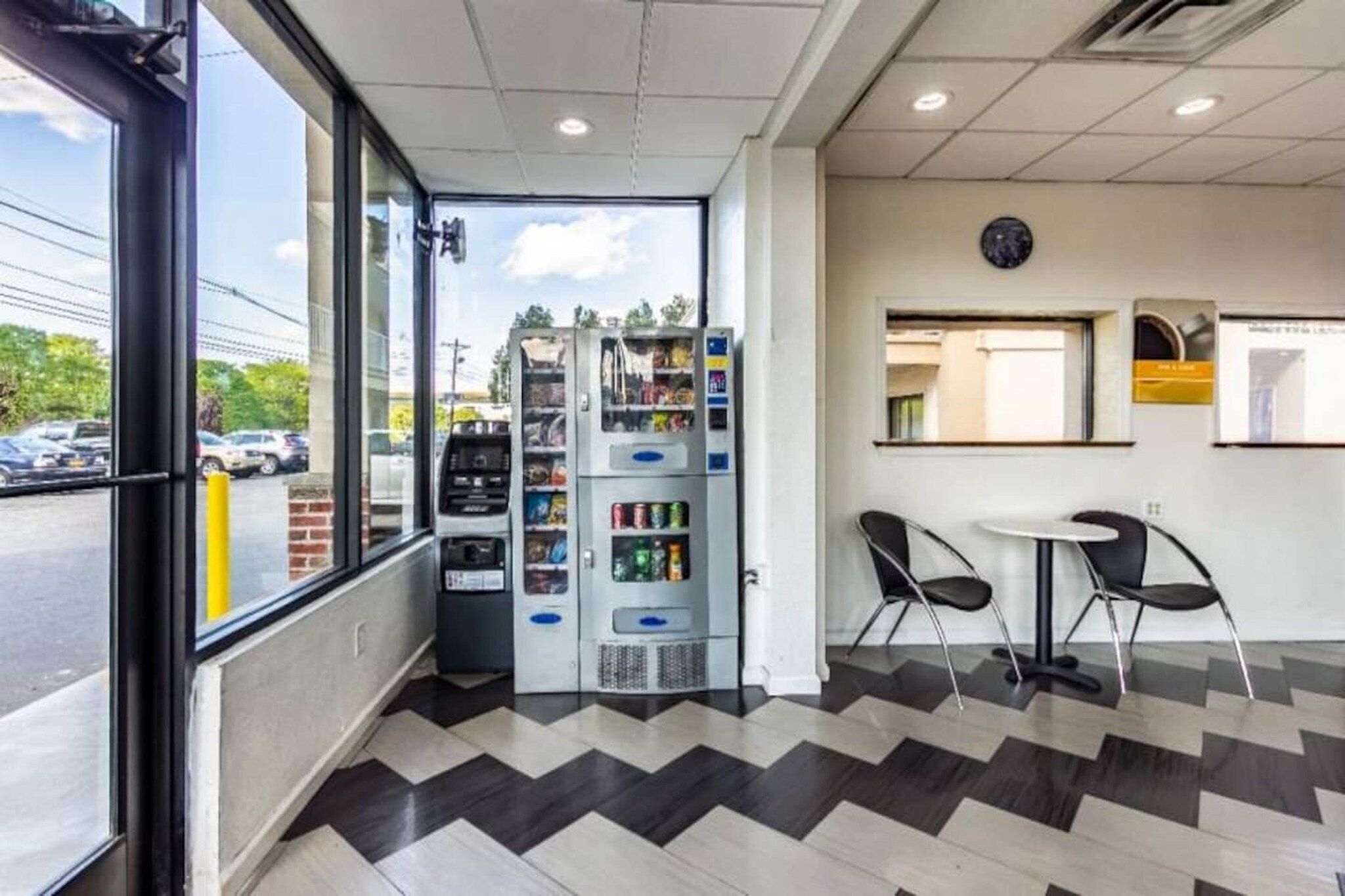 A modern interior with vending machines, a seating area, and a view of the outside.