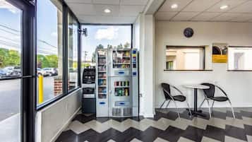 A modern interior with vending machines, a seating area, and a view of the outside.
