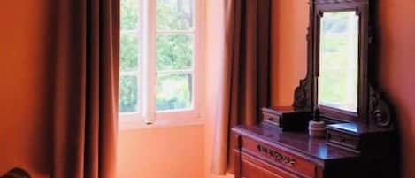 Una habitación con ventana, cómoda y silla.