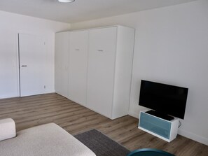 A room with a wardrobe, a television, and a sofa. - M Köhler Appartement/Fewo, Dusche oder Bad, WC 1-Zimmerwohnung by Interhome (Davos)