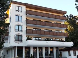 Un immeuble à plusieurs étages, doté de balcons, de grandes fenêtres et d’un toit plat.