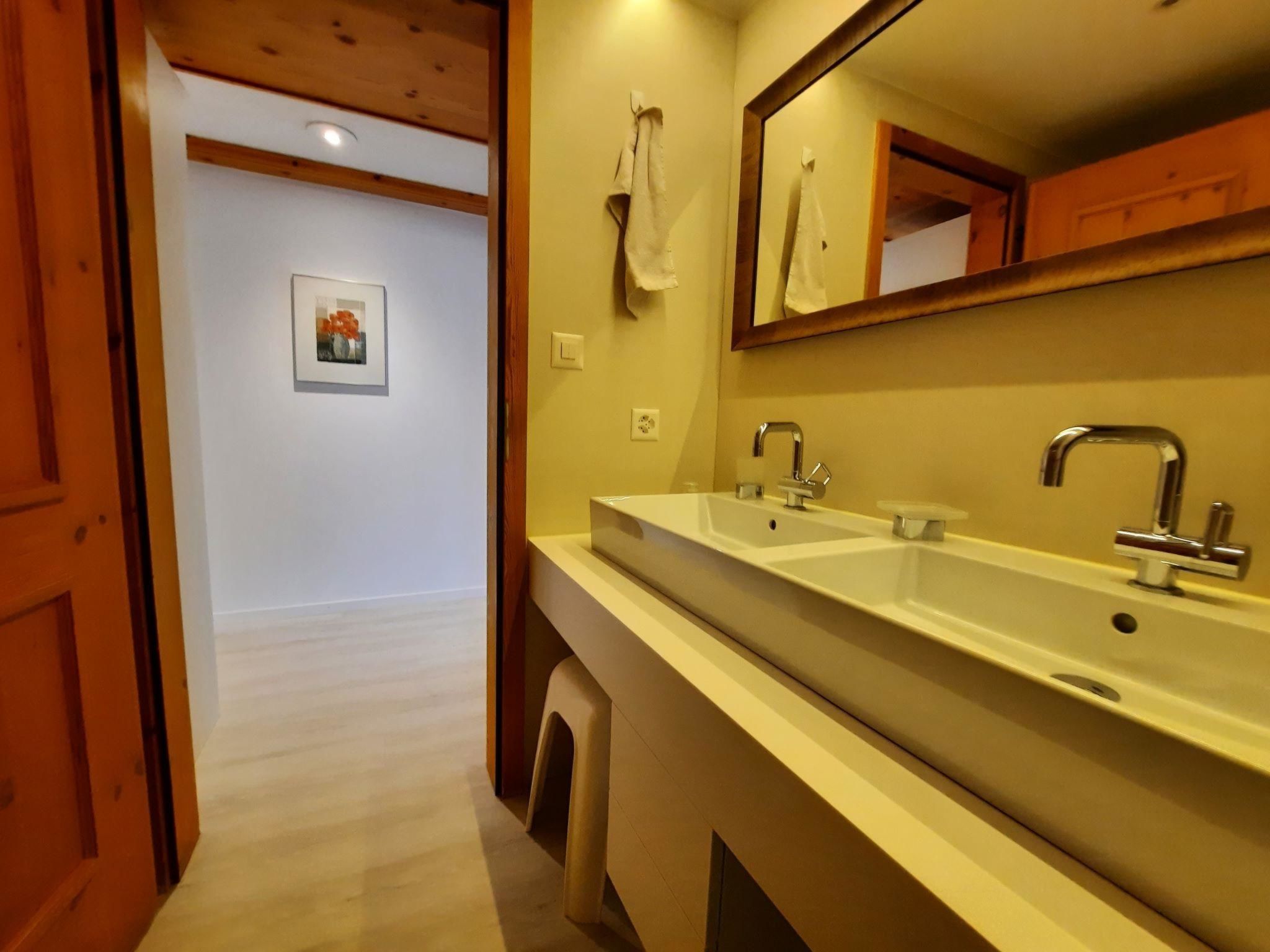 Un bagno con doppio lavabo, uno specchio e un asciugamano appeso al muro.