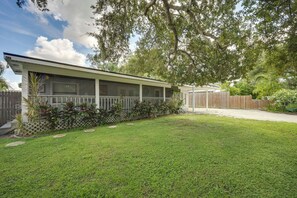 A single-story house with a covered porch, a fenced yard, and a wooden fence in the background. - 6 Mi to Beach! Sarasota Studio w/ Screened Porch (Sarasota)