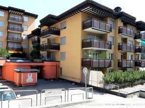 A multi-story residential building with balconies, a parking area, and a gated entrance. - Quellenhof C04 Appartement/Fewo, Dusche oder Bad, WC 2-Zimmerwohnung by Interhome (Davos)