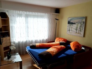 A bedroom with a bed, a desk, a chair, a radiator, and a painting on the wall. - Quellenhof C04 Appartement/Fewo, Dusche oder Bad, WC 2-Zimmerwohnung by Interhome (Davos)