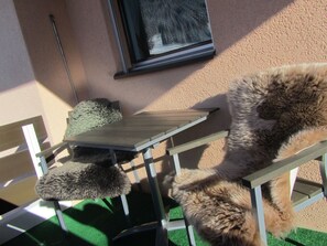 An outdoor seating area with a table and chairs, a window, and a wall. - Carlton am Golf C46 Appartement/Fewo, Dusche oder Bad, WC 2-Zimmerwohnung by Interhome (Davos)