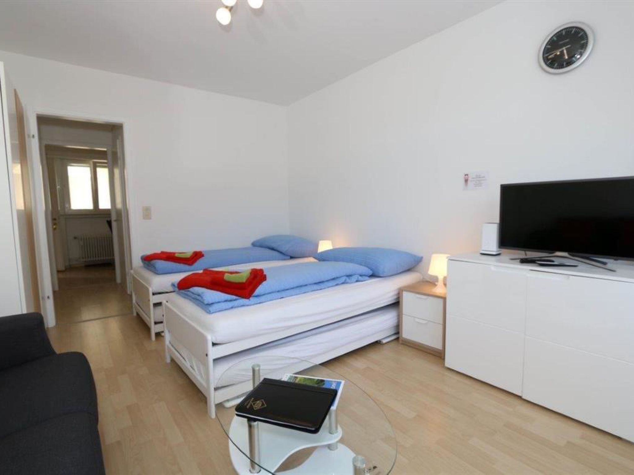 Une chambre avec deux lits, une télévision, un bureau et une chaise.