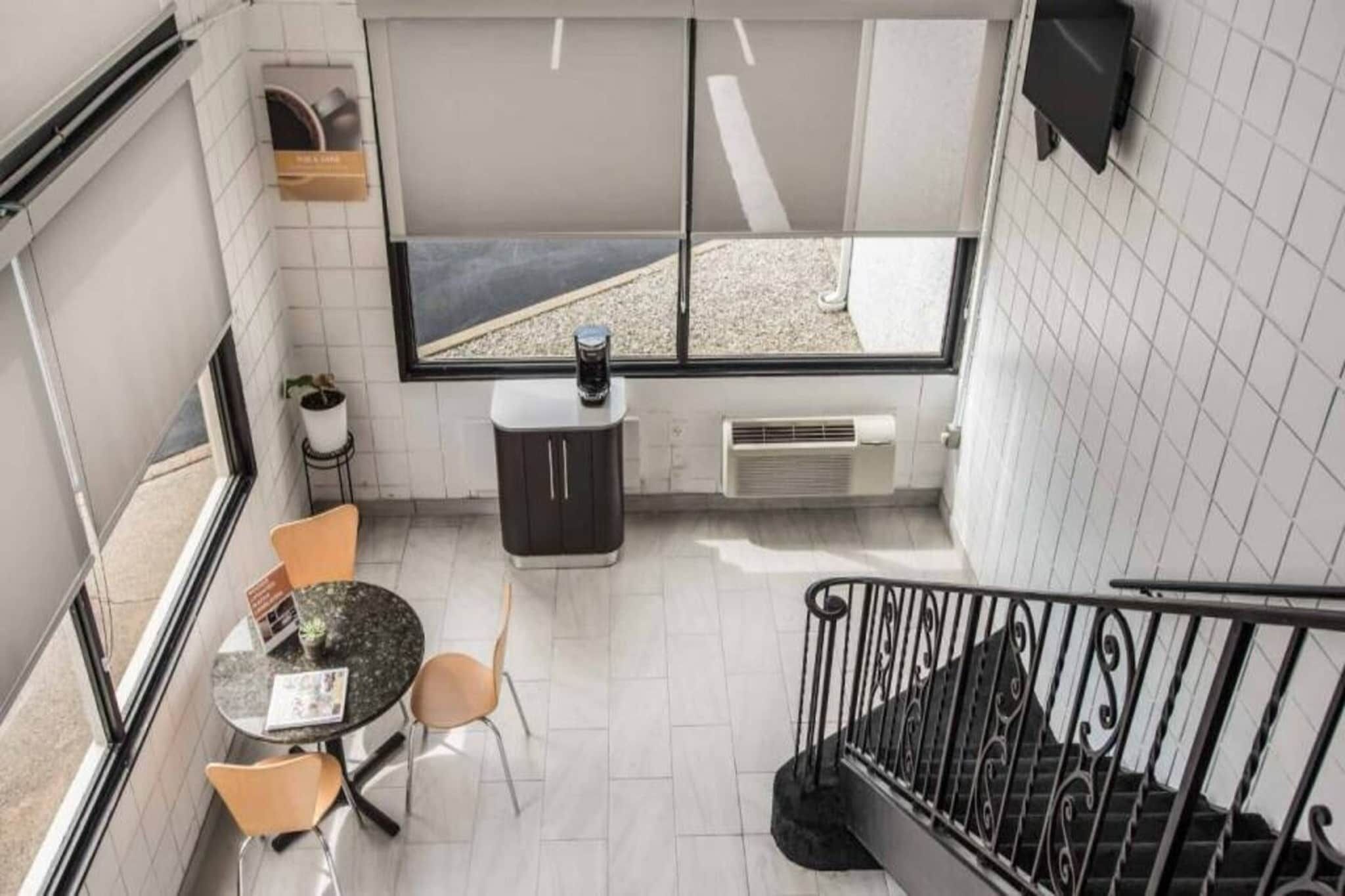 Ein gemütlicher Raum mit Esstisch, Stühlen, einer kleinen Küchenzeile und einem großen Fenster mit Ausblick.
