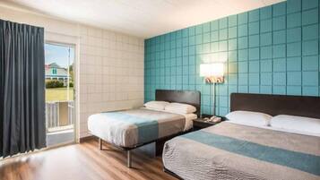 Habitación de hotel con dos camas, un balcón y vista a una casa.