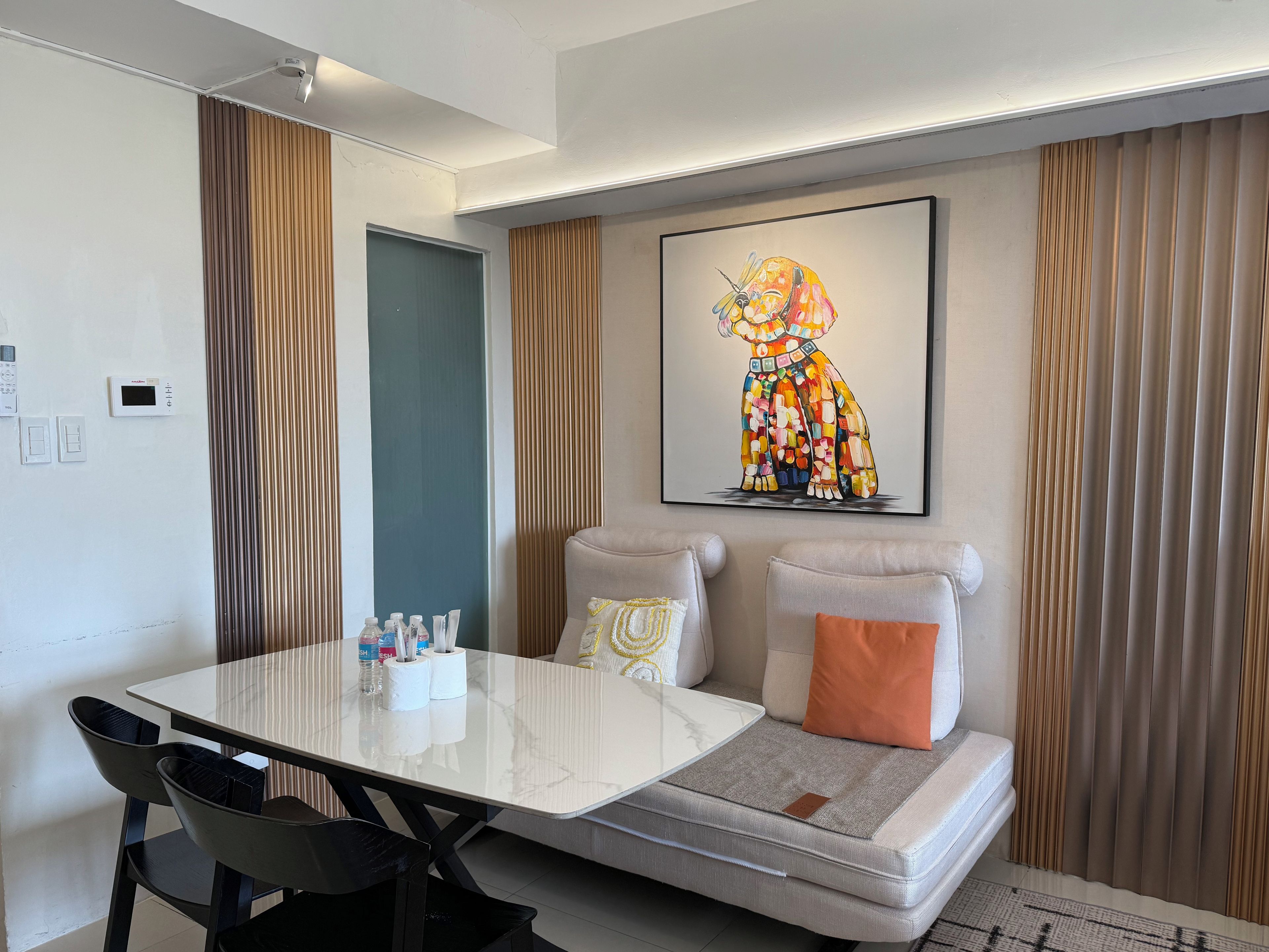 Uma sala de estar moderna com um sofá, uma mesa de centro e uma pintura na parede.