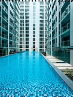 Ein modernes Gebäude mit einem zentralen Schwimmbecken, umgeben von mehreren Balkonagen.