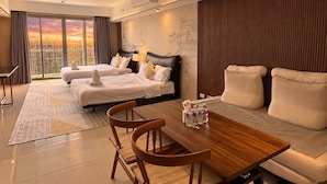 A hotel room with two beds, a dining table, and a sofa. - Modern Cozy Sunlit Apt Next to AirportS (Parañaque)