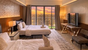 A hotel room with two beds, a TV, a desk, and a large window with a city view. - Modern Cozy Sunlit Apt Next to AirportS (Parañaque)