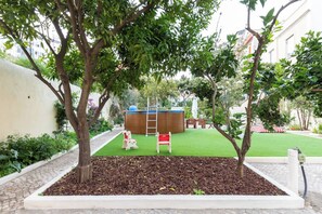 Ein angelegter Garten mit Spielbereich, inklusive Rutsche und kleiner Kletteranlage.