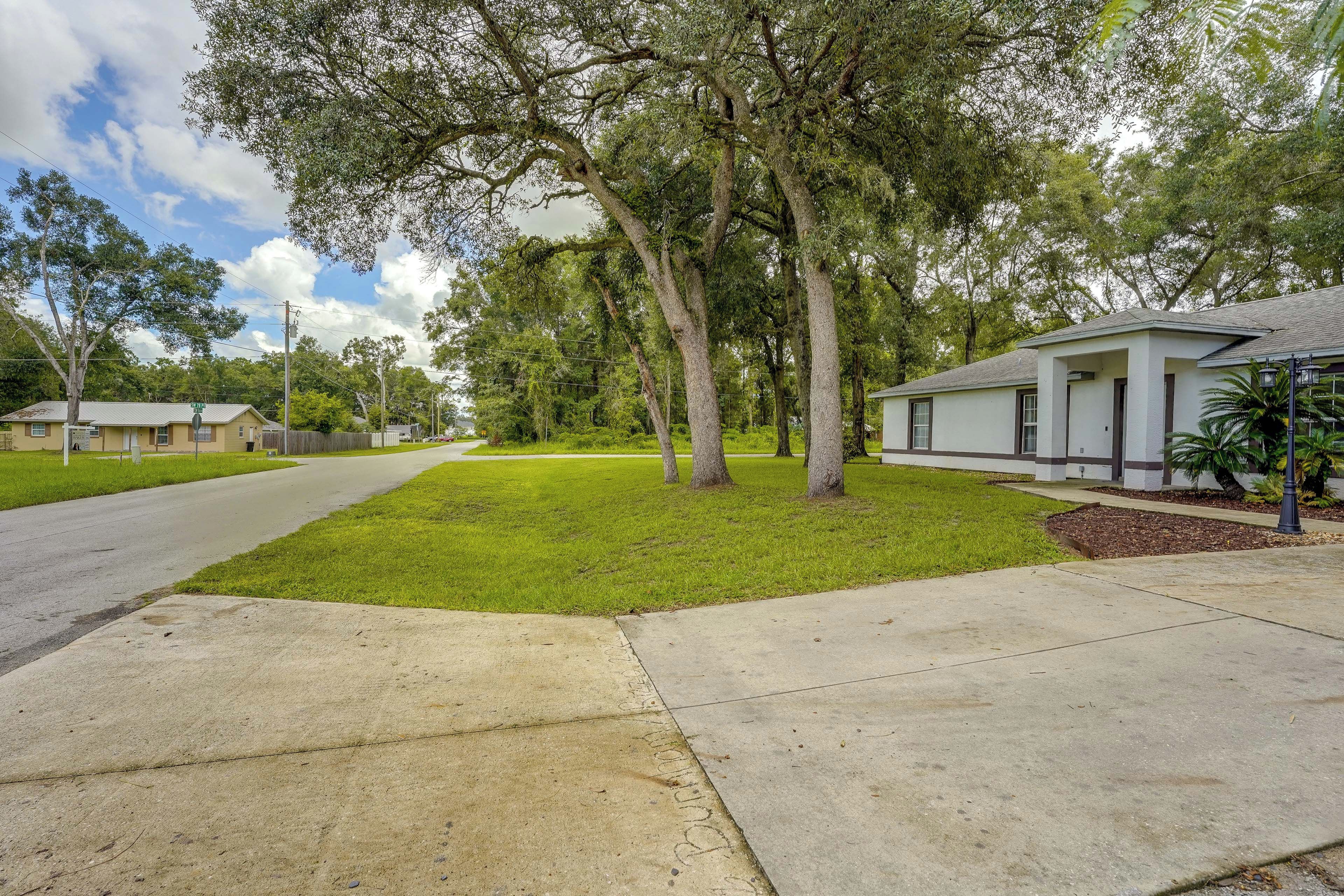 A residential street with houses, a sidewalk, and trees.