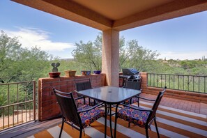 An outdoor patio with a table and chairs, a grill, and potted plants. - Desert-View Green Valley Retreat Near Golf Courses (Green Valley)