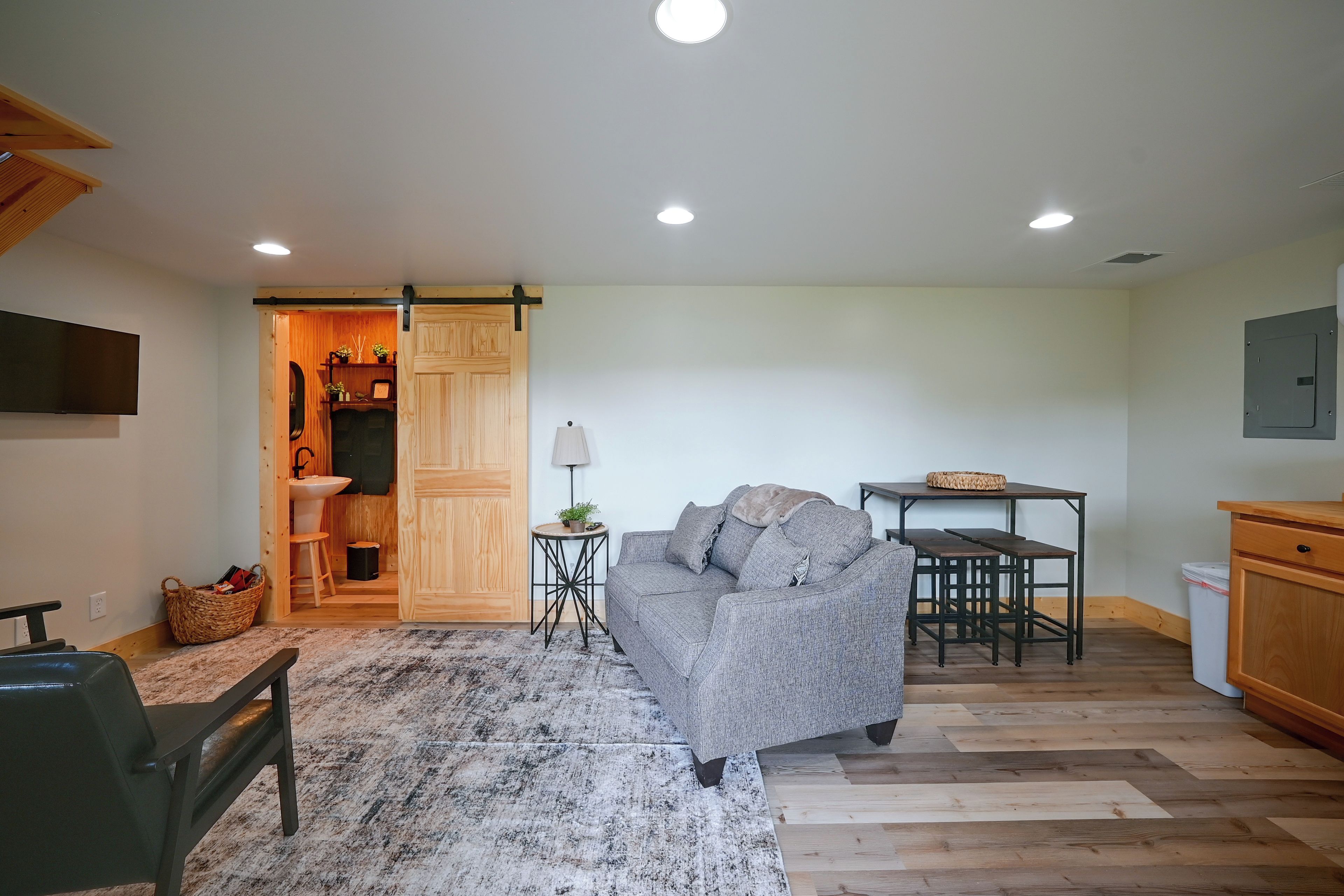 A living room with a sofa, a small table, and a wooden cabinet.