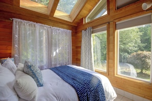 A bedroom with a large bed, two windows, and a skylight. - Walk to Beach! Kitsap Coast Retreat w/ Hot Tub (Hansville)