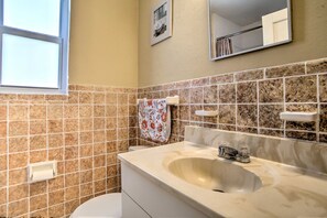 A bathroom with a toilet, sink, and mirror. - 1 Mi to Sand & Surf! 2-Unit Pompano Beach Escape (Pompano Beach)