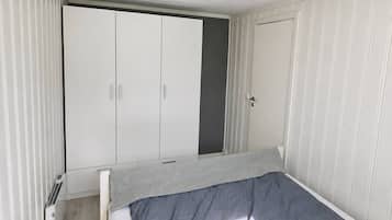 Ein Schlafzimmer mit einem Bett, einem Kleiderschrank und einer Heizung.