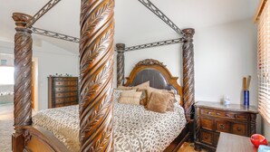 Un letto a baldacchino con struttura in legno e copripiumino a stampa leopardata.