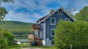 A two-story house with a deck, a dock, and a lake view. - On Neal Pond! Spacious Group Retreat w/ Game Room (Lunenburg)