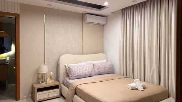 Una camera da letto moderna con un letto, un comodino, una lampada e un condizionatore d'aria.