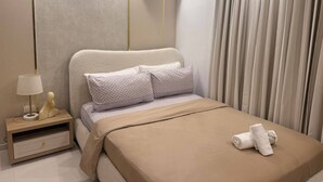 Una camera d'hotel moderna con un letto, un comodino, una lampada e un condizionatore.