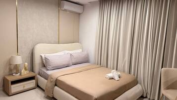 Un dormitorio moderno con una cama, una mesita de noche, una lámpara y una silla.