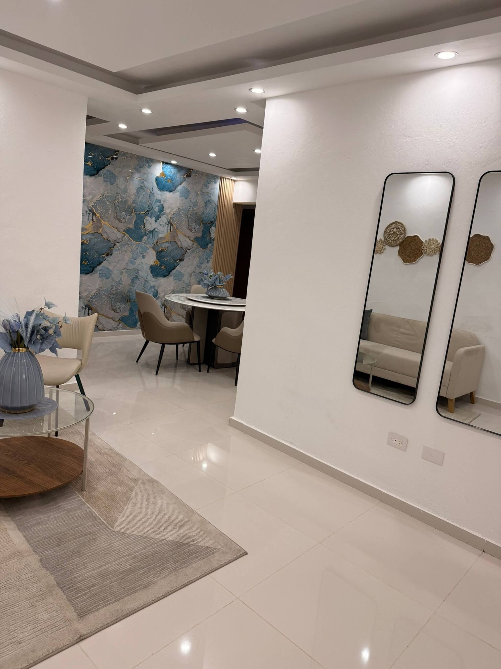 A modern dining area with a round table, chairs, and a decorative vase.